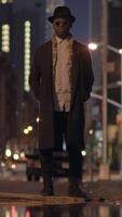 A stylish individual stands confidently in an urban setting during the enchanting night hours video