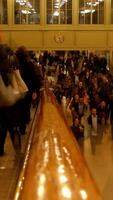 A large and diverse crowd gathered in a busy, vibrant indoor space, full of life and energy video