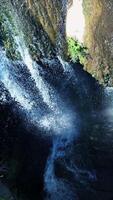 A serene waterfall cascading through a rocky cliff, creating a beautiful scene to enjoy video