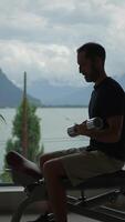 The striking silhouette of a man engaging in an intense workout with a dumbbell by the lake video