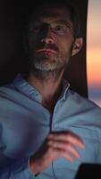 A thoughtful man is captured in the warm glow of evening light, immersed in deep reflection video