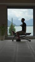 Silhouette of a Man Engaged in Exercising by the Window, Overlooking a Scenic View video