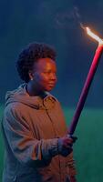A lone torch bearer navigates through a dark forest, creating an enigmatic nighttime atmosphere video