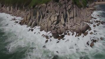 Aerial view of a rocky promontory on which powerful waves crash video
