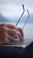 Engaging in Focused Work Using a Laptop and Wearing Glasses While Relaxing by the Water video