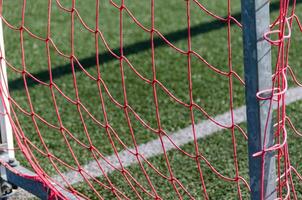 red netting of a football goal of an artificial turf field photo