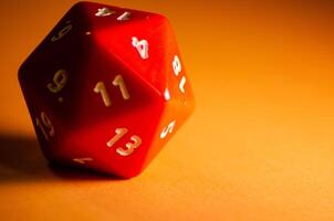 selective focus 20-sided red dice for role-playing game isolated on warm background photo