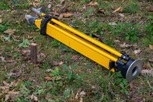 Stake driven into the ground as a topographic base and tripod for the total station. Survey work concept. photo