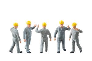 Miniature construction worker dressed in a jumpsuit isolate on white background with clipping path jumpsuit isolate on white background with clipping path photo
