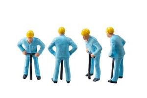 Miniature construction worker in a blue uniform isolate on white background with clipping path photo