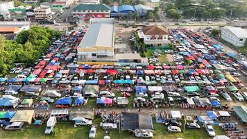 An aerial view of a large market with tents and cars photo