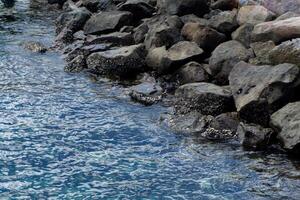 Ocean wave to the rock at the beach. limpets aquatic snails attached to the rocks at the beach in Rubiah island in Sabang indonesia photo