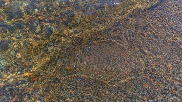 Coastal sand in the clear water of the lake. photo
