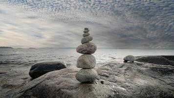 Stacked Rocks balancing, stacking with precision. Stone tower on the shore. Copy space photo