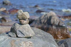 Stacked Rocks balancing, stacking with precision. Stone tower on the shore. Copy space photo