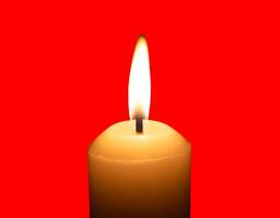 A single burning candle flame or light glowing on a big white candle isolated on red background with clipping path photo