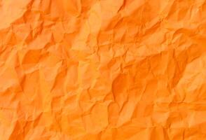 Top view and full frame of wrinkled or crumpled orange paper used as crumpled orange paper background texture. photo