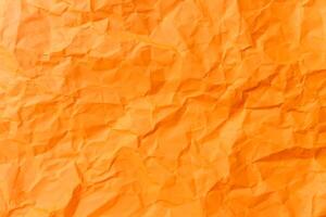 Top view and full frame of wrinkled or crumpled orange paper used as crumpled orange paper background texture. photo
