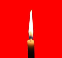 A single burning candle flame or light glowing on a small white candle isolated on red background with clipping path photo