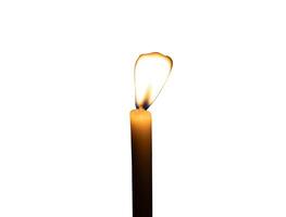 A single burning candle flame or light glowing on a small white candle isolated on white background with clipping path photo