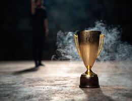 golden trophy with smoke in dark background photo