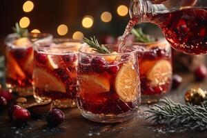Christmas Sangria Being Poured into Glasses, Garnished with Fresh Fruit, Cranberries, and Rosemary photo