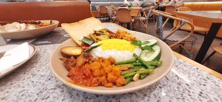 Delicious Nasi langgi menu made in Rempah Bistro restaurant located on shopping mall. Makassar, South Sulawesi, Indonesia - August 27 2024 photo