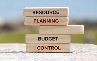 Resource planning and budget control text on wooden blocks with blurred nature background photo