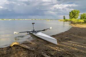 Coastal rowing shell on a shore of Boyd Lake in northern Colorado in early spring scenery. photo