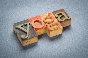 yoga word - text in letterpress wood type printing blocks stained by color inks on art paper photo