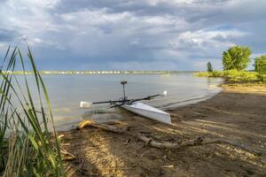 Coastal rowing shell on a shore of Boyd Lake in northern Colorado in late spring or summer scenery. photo