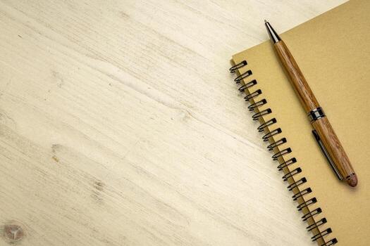 spiral notebook with w a pen on distressed wood background with a copy space photo