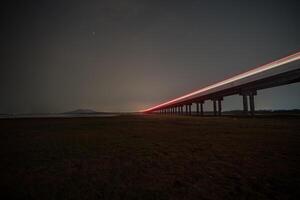 Train is moving on rail at night time with background of star location at thailand photo