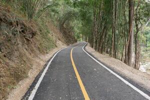 Curve of long road across through mountain view under cloudy sky photo
