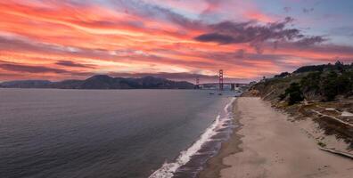 Golden Gate Bridge with Sandy Beach and Rugged Coastline in View photo