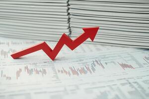 A vivid red downward arrow crashes through a backdrop of financial reports, symbolizing a significant downturn. The contrast highlights the severity of the situation in economic terms. photo