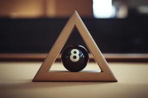 An isolated black snooker ball sits perfectly within a wooden triangle, set on a smooth felt surface in a tranquil and dimly lit room, highlighting its glossy finish and simple elegance. photo