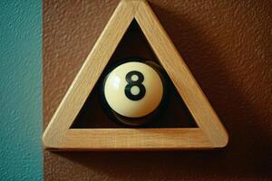 A single snooker ball is positioned within a wooden triangle, set against a textured wall. The balls number is clearly visible, emphasizing its isolation in this unique arrangement. photo