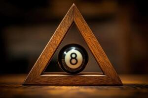 A solitary black snooker ball with the number eight is nestled in a wooden triangle rack. The rustic table surface adds warmth, creating a classic billiards atmosphere. photo