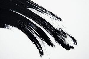 Bold black brush strokes sweep across a pristine white background, showcasing a striking contrast and creative potential. The work highlights both movement and simplicity in design. photo