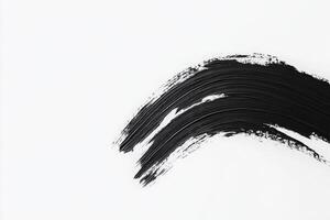 Bold black brush strokes sweep across a pristine white canvas, creating a visually striking contrast. The strokes vary in thickness and texture, showcasing the artistry involved in the creation. photo