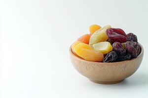 A bowl filled with assorted dried fruits, including apricots, cranberries, and raisins, sits on a clean, minimalist surface, emphasizing the vibrant colors and textures of the snacks. photo