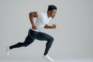 An athletic runner is captured in mid-sprint on a clean solid white background. The individual showcases impressive speed and form, emphasizing athleticism and dedication to the sport. photo
