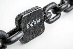 A detailed view of a black chain link with a block labeled blockchain highlights the essential structure and connections vital to this technologys function and security. photo