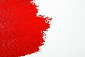 Vivid red brush strokes are applied to a pristine white canvas, showcasing an abstract art style. The bold strokes create a striking visual impact and emphasize color contrast. photo