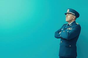 A border control officer stands with arms crossed, looking to the side. His uniform displays authority and commitment, set against a clean, bright blue backdrop that emphasizes professionalism. photo