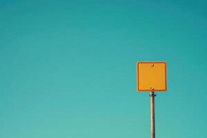A solitary yellow border crossing sign is prominently displayed, set against a vast, clear blue sky. The scene radiates tranquility in an open space, devoid of other distractions. photo