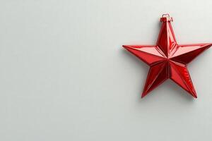 A bright red Christmas star ornament is displayed, hanging gracefully against a plain, solid background, embodying the festive spirit of the holiday season with its striking color and shape. photo