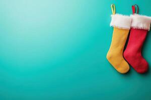 Two vibrant Christmas stockings, one yellow and one red, are neatly displayed against a clean blue background, ready to be filled with holiday treats and surprises for the festive season. photo