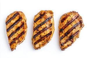 Three perfectly grilled chicken slices are arranged in the center, highlighting their juicy texture and appetizing grill marks. Ideal for a nutritious meal or recipe inspiration. photo